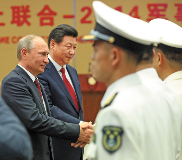 Président Xi Jinping et son homologue russe Vladimir Poutine assistent au début de manoeuvres communes entre les marines des deux pays, mardi à Shanghai. L'exercice qui a lieu dans la partie nord de la Mer de Chine orientale durera une semaine. [Photo Wu Zhiyi / China Daily]