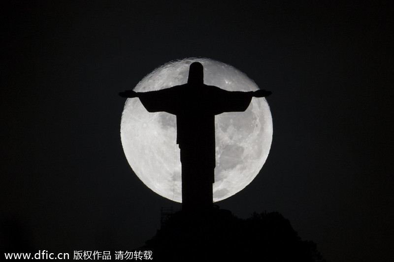 La silhouette de la statue du Christ Rédempteur devant une pleine lune à Rio de Janeiro, au Brésil, le 31 mai 2014. [Photo/IC]