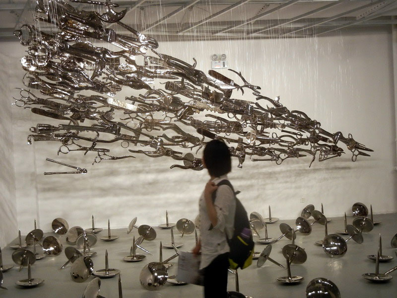 Une visiteuse admire une œuvre d'art en céramique de Liu Danhua intitulée « Les Punaises », au Musée d‘Art du Lac Jinji de Suzhou, le 24 mai 2014. [Photo Wang Jiankang / asianewsphoto.com]