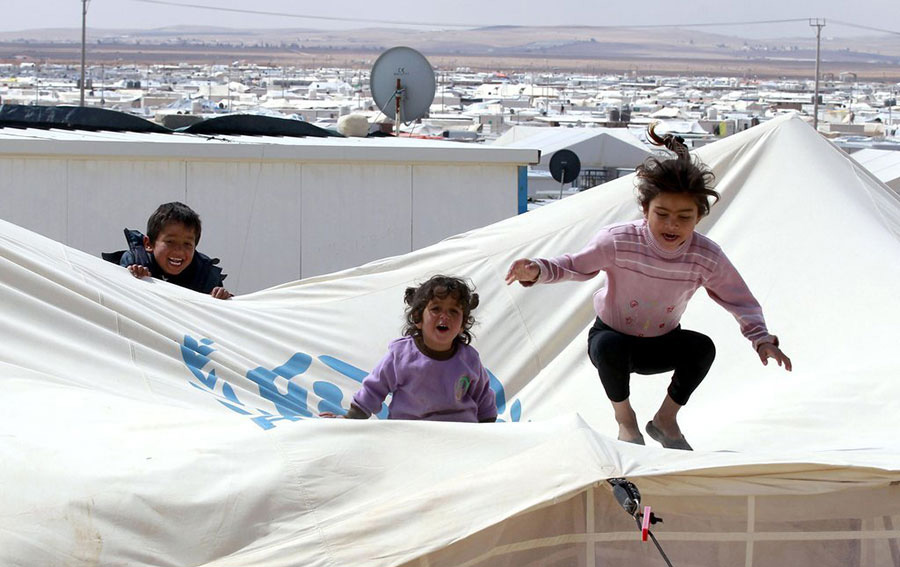 Sur cette image prise le 15 mars 2014,on aperçoit trois enfants jouant dans un camp de réfugiés dans le désert Zaatari, au nord de la Jordanie près de la frontière avec la Syrie. Site offrant un abri pour environ 100 000 réfugiés syriens. Une guerre brutale a éclaté en Syrie entre le régime d'Assad et ses ennemis et depuis n’a pas faibli, en tuant au moins 146 000 personnes depuis mars 2011. Plus de 2,5 millions de Syriens ont fui à l'étranger et un autre 6,5 millions ont été déplacées à l'intérieur du pays. La Jordanie abritant plus de 500 000 réfugiés. 