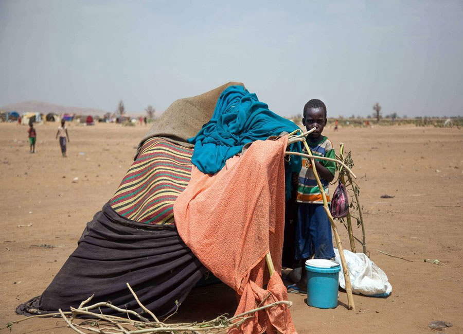 Une photo publiée par la Mission de l'Union africaine-Nations unies au Darfour, montre un enfant soudanais devant son abri de fortune, au camp de Kalma, le 9 mars 2014 (Sud du Darfour). 