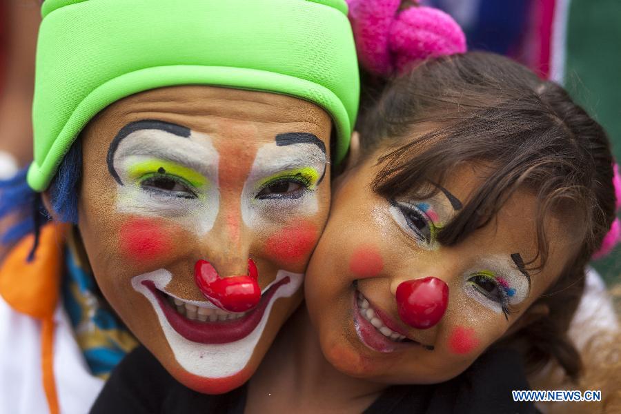 Deux clowns posent pour des photos lors de la sixième parade du Congrès latino-américain des clowns, au Centre Historique de la ville de Guatemala, le 29 juillet 2014. (Xinhua/Luis Echeverria)