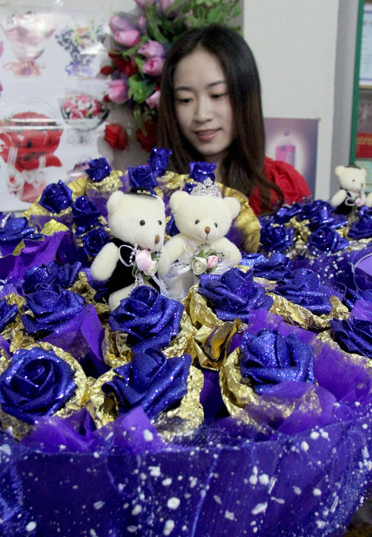 Une vendeuse montre des roses faites à la main, dans la ville de Lianyungang, dans la Province du Jiangsu, en Chine de l'Est, le 30 juillet 2014. 