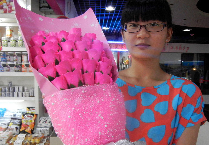 Une vendeuse montre un bouquet de roses en savon dans la ville de Suzhou, dans la Province du Jiangsu, en Chine de l'Est, le 30 juillet 2014. 