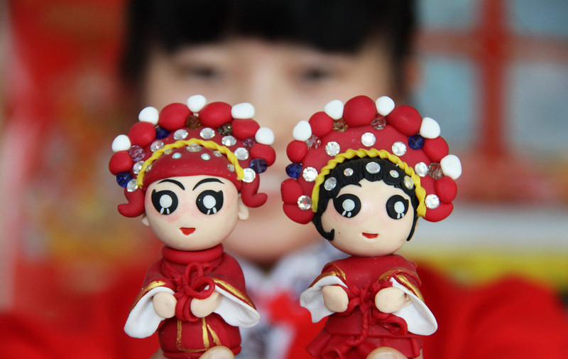 Un couple de figurines de pâte, vu dans un magasin de fabrication de sujets en pâte, dans le Comté de Wanrong, dans la Province du Shanxi, en Chine du Nord, le 29 juillet 2014. 