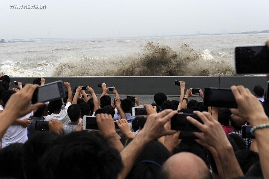 Des spectateurs rassemblés sur les rives du fleuve pour admirer le mascaret de la rivière Qiantang à Yanguan (ville de Haining), dans la Province du Zhejiang à l'Est de la Chine, le 11 septembre 2014. C’est lors du huitième mois du calendrier lunaire chinois que le mascaret de la rivière Qiantang voit déferler les plus hautes vagues. (Xinhua / Han Chuanhao)