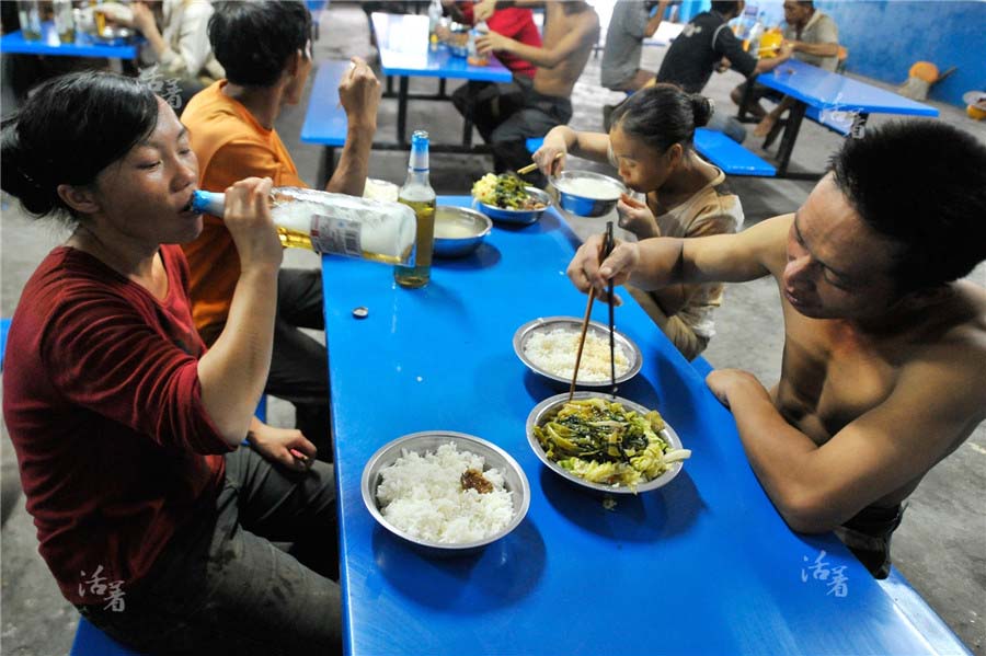Yang Yashan savoure une bière alors que son mari dîne. La cantine sur le site de construction propose des repas à partir de 8 yuans (un peu plus d'un euro) par personne. [Photo/qq.com]