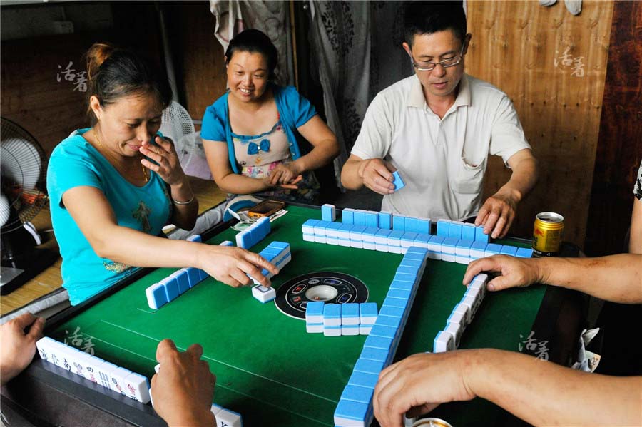 Un jour de pluie, des travailleuses dans le milieu de la construction jouent au mahjong, n'ayant guère d'autre forme de divertissement. [Photo/qq.com]