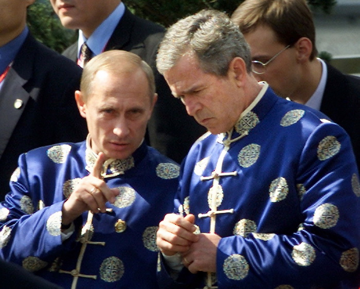 En pleine conversation, le président russe Vladimir Poutine (à gauche) et l'ancien président américain George W. Bush (à droite), portent une veste traditionnelle chinoise de soie, lors de la réunion des dirigeants de l'APEC à Shanghai, le 21 octobre 2001.