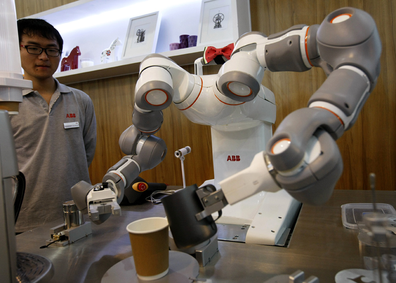 Un robot rend une tasse de café pendant le 16e Salon international de l'industrie de Chine à Shanghai, le 4 novembre 2014. [Photo/Xinhua]