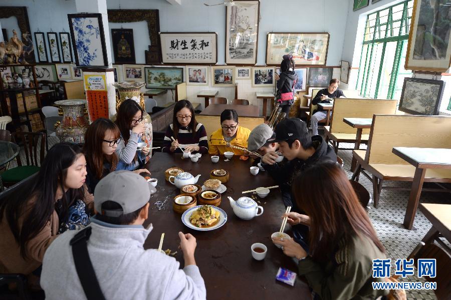 Des jeunes de Aomen (澳门) prennent le petit-déjeuner dans la maison de thé de Longhua. Etant l’établissement le plus ancien de la ville, Longhua a su préserver une authentique gastronomie locale.