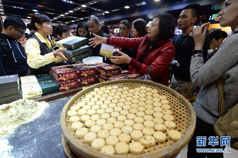 Des touristes achètent des gâteaux aux amandes, une pâtisserie traditionnelle de Macao.