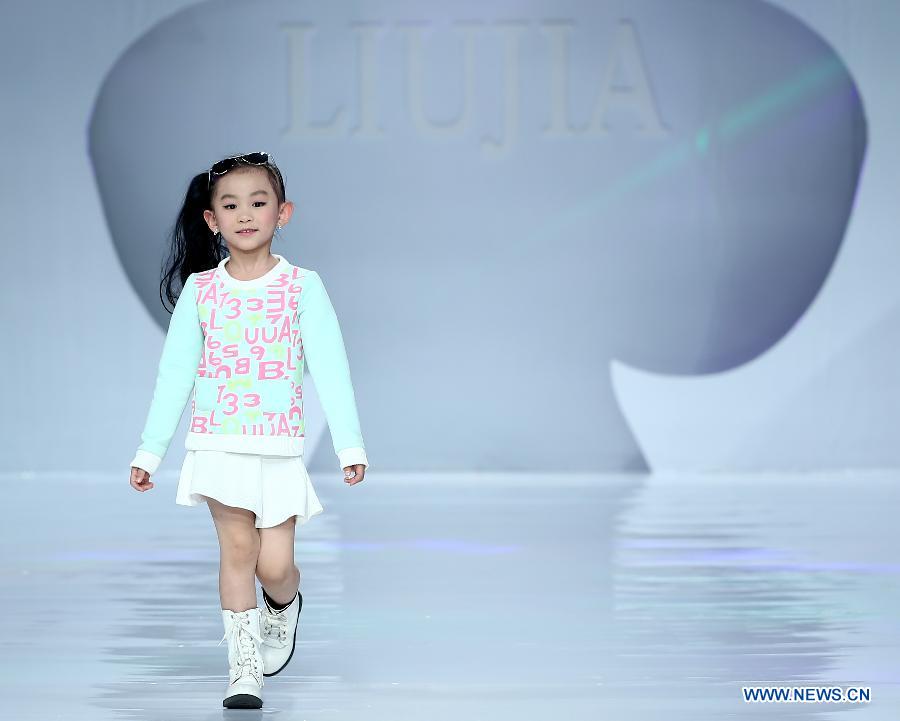 Un petit mannequin présente une création du styliste Liu Jia lors d'un défilé dans le cadre de la fashion week Chine-ASEAN à Nanning, au Guangxi, le 2 janvier 2015.