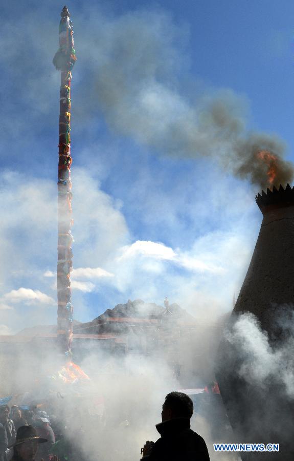 Des dévots tend des drapeaux de prière sur un poteau près du temple de Jokhang à Lhassa, capitale de la région autonome du Tibet dans le sud-ouest de la Chine, le 11 février 2015 .