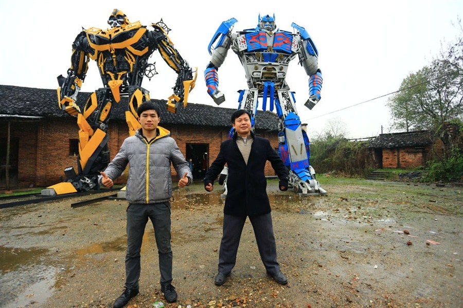 Yu Zhilin (à droite) et son fils Yu Lingyun prennent la pose devant deux transformers géants dans le comté de Hengyang, la province du Hunan (centre de la Chine). Les agriculteurs du village de Caotian ont commencé depuis 2007 à utiliser des vieilles pièces de voiture pour fabriquer des Transformers. Il leur a fallu trois ans pour terminer leur premiers modèles. Dès cette année, Yu a indiqué avoir gagné plus d'un million de yuans (160,000 ) avec la vente ou la location de ces monstres mécaniques. [Photo:Xinhua]