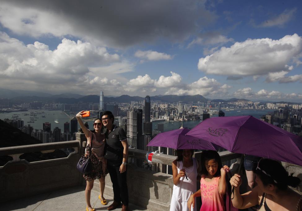 Des touristes de la partie continentale de Chine admirent des paysages dans un gratte-ciel à Hong Kong.
