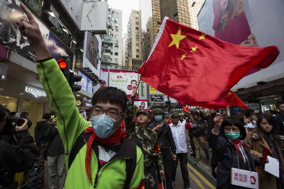 Des manifestants et leur slogan « Aimer la patrie, utiliser des produits ‘made in China' » pour protester contre les revendeurs de produits hors-taxes.