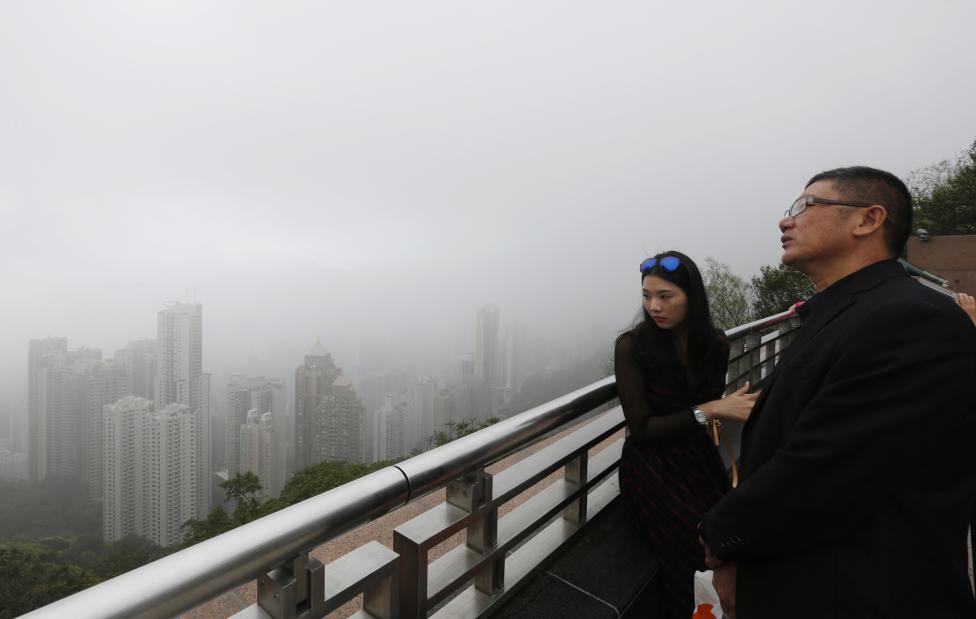 Des touristes chinois admirent les paysages de Hong Kong dans un gratte-ciel.
