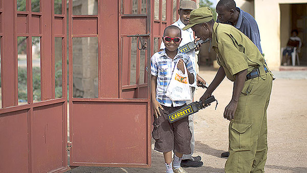 Un jeune chrétien passe au détecteurs de métaux, près d'une église attaquée par les Shebab.