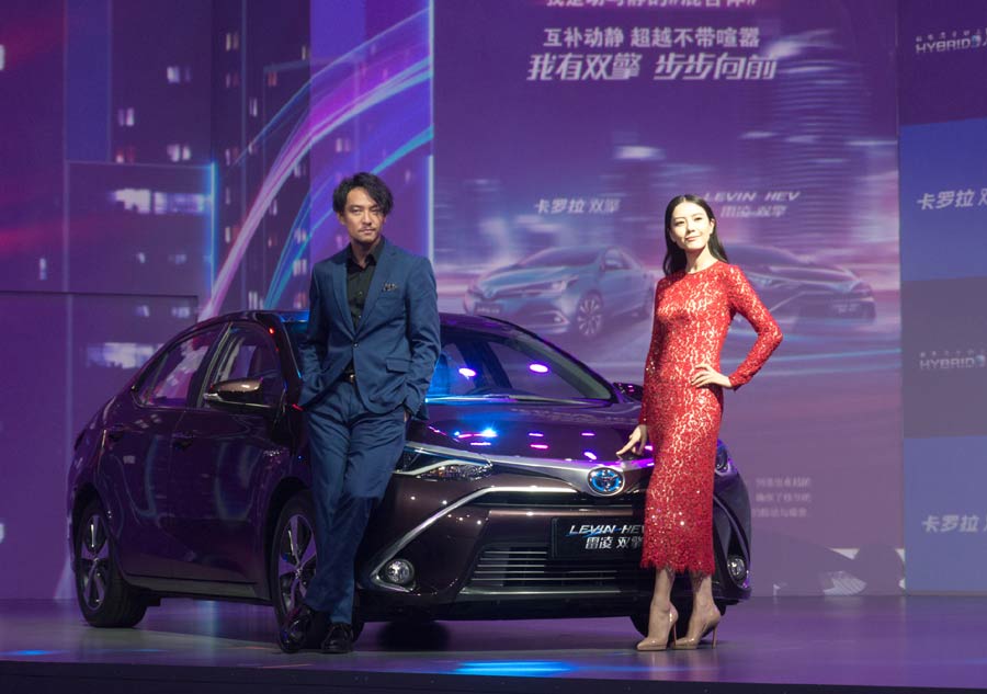 Pose de luxe, pour les acteurs chinois Zhang Zhen et Gao Yuanyuan, aux côtés de la Toyota Levin Twin Engine hybrid, à l'occasion du 16e Salon international de l'automobile de Shanghai, le 20 avril 2015. [Photo/IC].