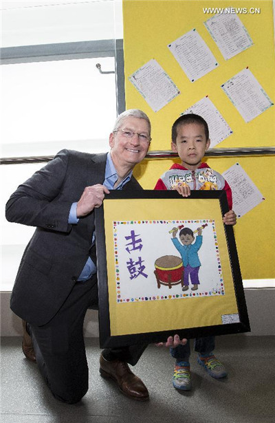 Un élève présente sa peinture à Tim Cook. [Photo / Xinhua]