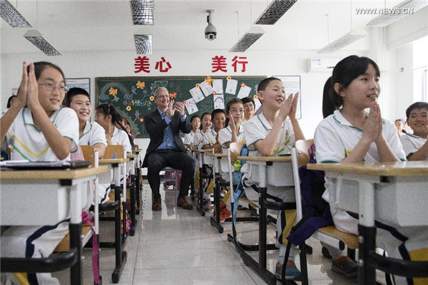 Tim Cook, au fond de la classe, assiste à une leçon d'anglais oral à l'école primaire de l'Université de Communication de Chine, le 12 mai 2015. [Photo / Xinhua]
