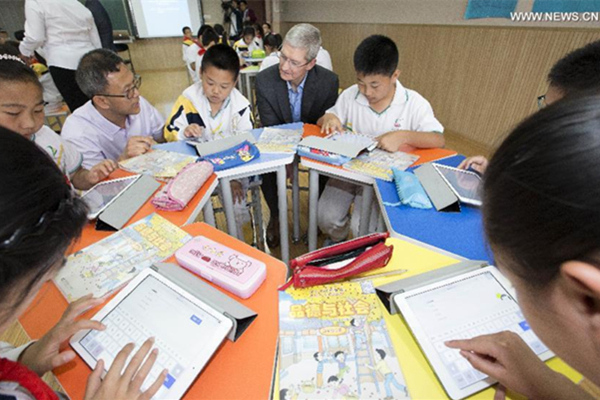 Tim Cook, au centre, assiste à une leçon à l'école primaire de l'Université de Communication de Chine, le 12 mai 2015. [Photo / Xinhua]