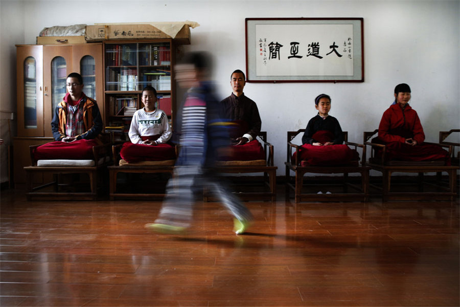 De bon matin, Bai Zilin, au centre, médite avec ses élèves. [Photo / CFP]
