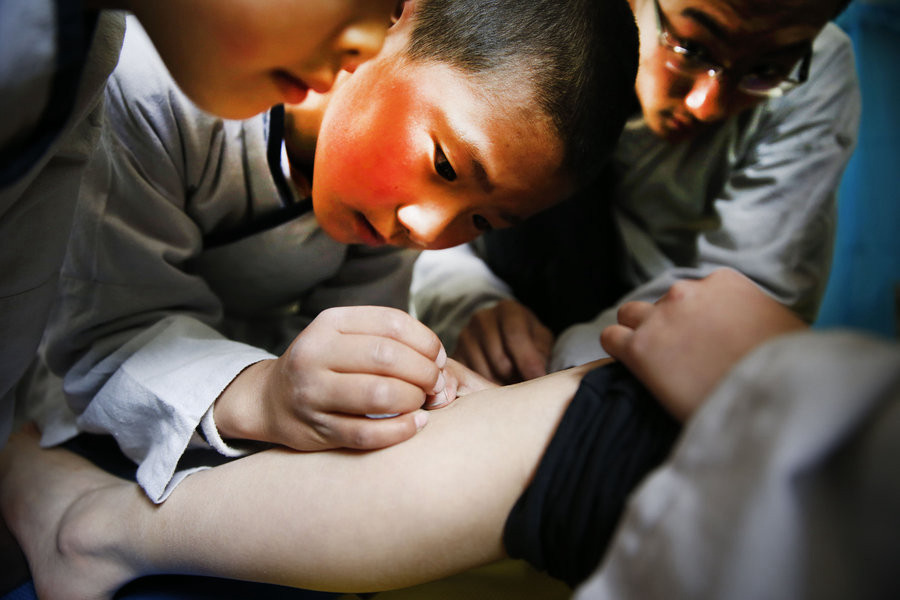 Les élèves pratiquent l'acupuncture, l'une des cinq branches de la médecine traditionnelle chinoise. [Photo/CFP]