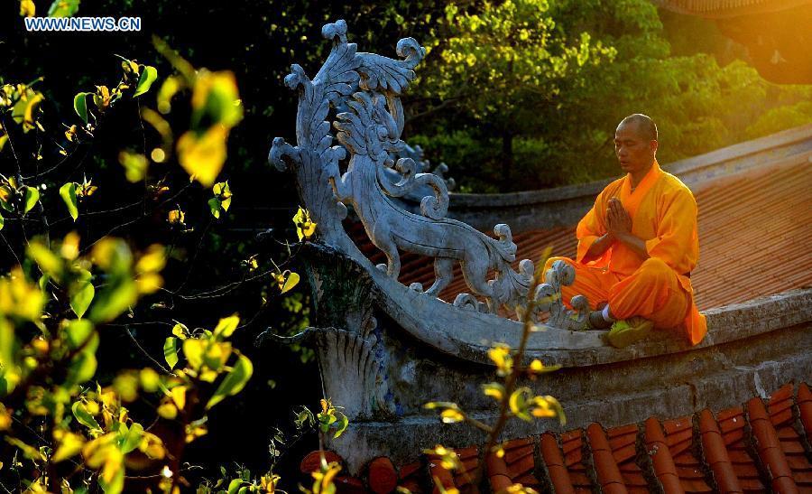 Un moine médite sur un toit du temple Shaolin de Quanzhou, dans la province chinoise du Fujian (sud-est), le 13 mai 2015.