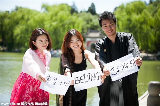 Trois étudiants étrangers vêtus de leurs costumes nationaux à l'Université de Pékin