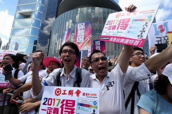 Des citoyens portent des pancartes et crient des slogans devant le siège du Conseil législatif, situé dans le quartier de l'Amirauté, pour soutenir le programme de réforme électorale du gouvernement de Hong Kong, le 17 juin 2015. Roy Liu / China Daily