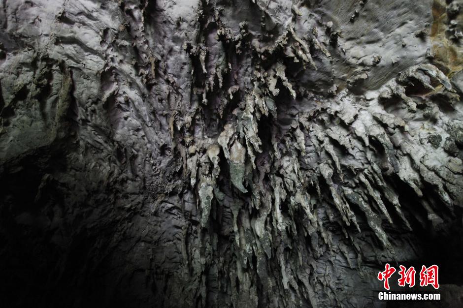 Un embut au fond de la cavité, où se sont formées de nombreuses stalactites.