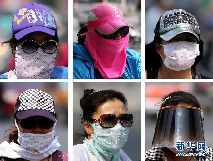 Des résidents de Lianyungang (province chinoise du Jiangsu) bien « armés » pour se protéger du soleil, le 13 juillet 2015.