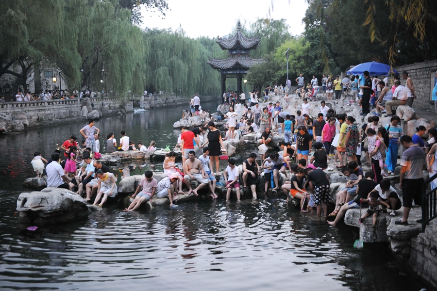 Cette image prise le 26 juillet 2015 à Jinan dans la province du Shandong (centre de la Chine) montre une centaine de personnes se trempant les pieds dans la source de Baishi.