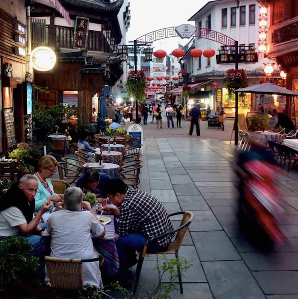 Des touristes mangent des snacks locaux dans une ancienne rue de la ville de Huangshan, dans la province chinoise de l'Anhui (est), le 10 octobre 2014.