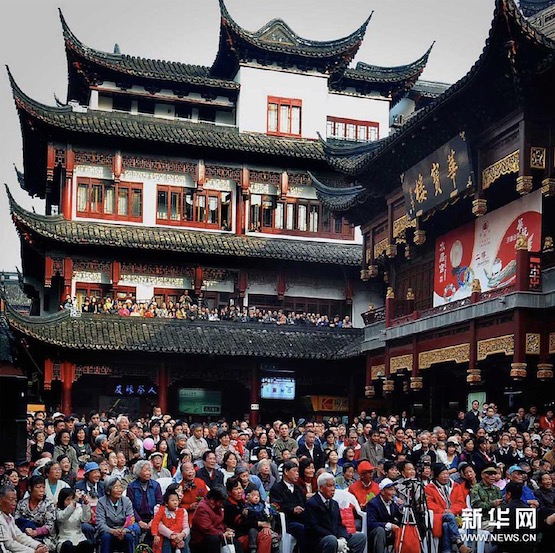 Des touristes regardent une démonstration d’art folklorique au jardin Yuyuan à Shanghai.