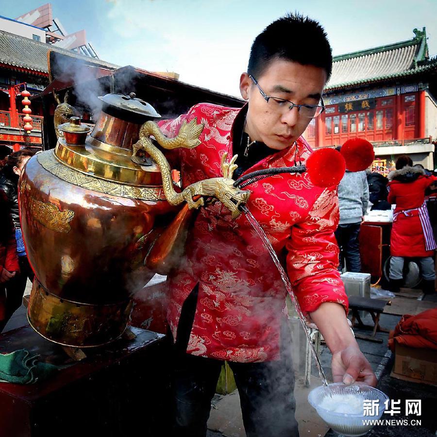 Un vendeur sert du thé aux amandes aux touristes dans la rue de la culture ancienne à Tianjin.