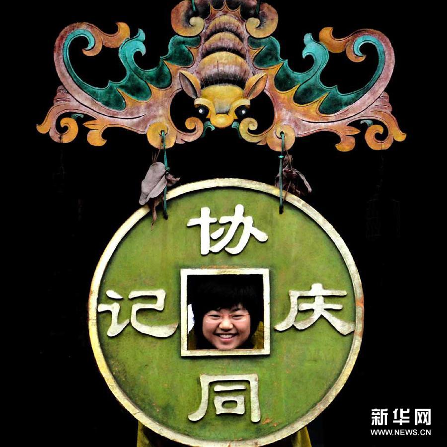 Une touriste pose pour une photo dans la rue du sud de Pingyao (Shanxi).