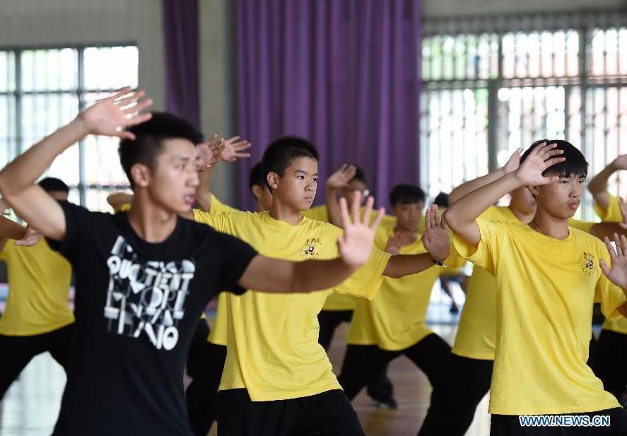 Des jeunes apprennent le tai-chi Kung Fu Fan pendant leur camp d'été