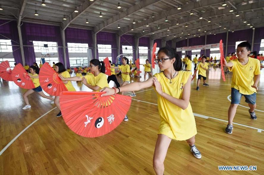 Des jeunes apprennent le tai-chi Kung Fu Fan pendant leur camp d'été