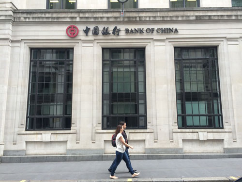 (Des piétons passent devant la succursale londonienne de la Banque de Chine, située en plein cœur de la City de Londres. Source : le Quotidien du Peuple)