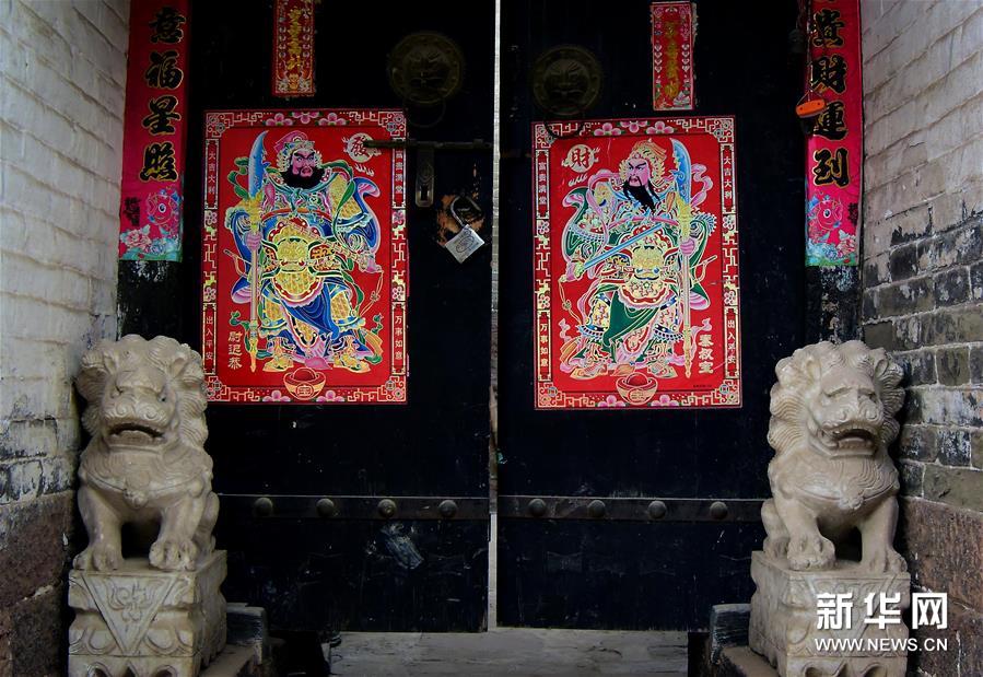 Les images des dieux de la porte fleurissent sur les maisons chinoises