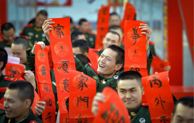 Des soldats écrivent leurs vœux de Fête du Printemps en calligraphie pour leur famille. (Photo Hou Chonghui / pour chinadaily.com.cn)
