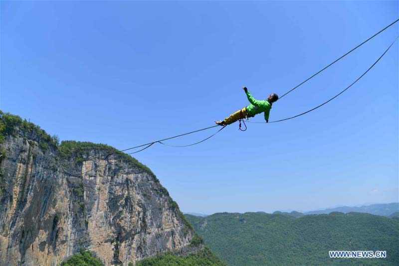 Homme fait de l'équilibre sur un fil dans une base de sports de plein air au Hubei