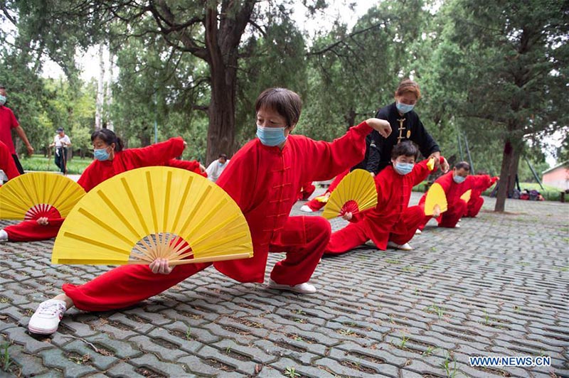 Les personnes âgées pratiquent l'aérobic traditionnel au parc du Temple du Ciel à Beijing