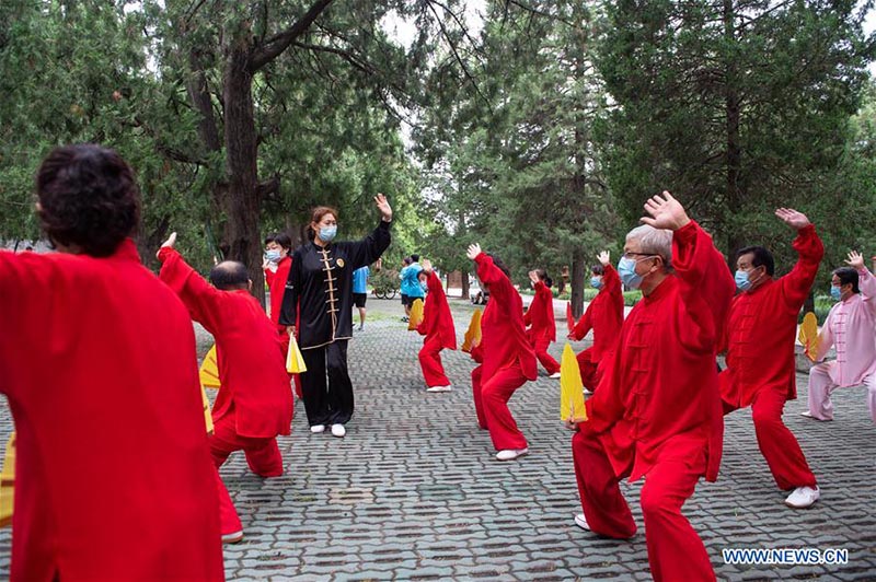 Les personnes âgées pratiquent l'aérobic traditionnel au parc du Temple du Ciel à Beijing