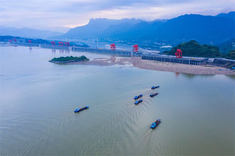 Des bateaux nettoient les objets flottants devant le barrage des Trois Gorges à Yichang, dans le Hubei