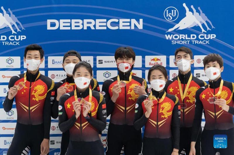 Les membres de l'équipe de Chine manifestent leur joie lors de la cérémonie de remise des prix après la finale du relais mixte 2000 mètres lors de la Coupe du monde de l'International Skating Union de patinage de vitesse sur courte piste à Debrecen, en Hongrie, le 21 novembre 2021. (Attila Volgyi / Xinhua)