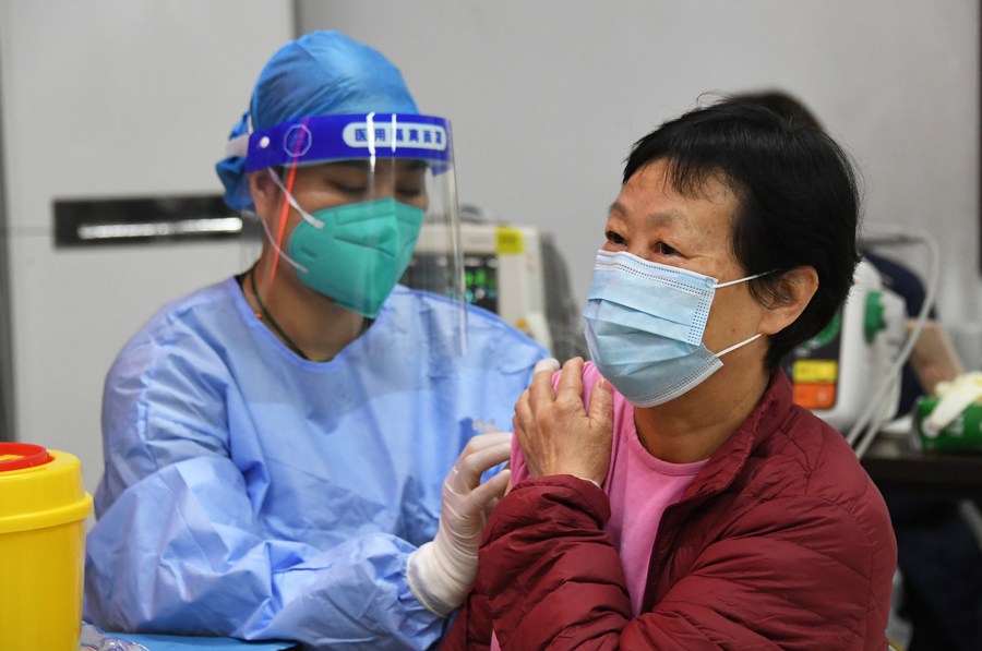 Une professionnelle de santé administre une dose de rappel du vaccin contre la COVID-19 à une habitante locale sur un site de vaccination temporaire, à Beijing, capitale chinoise, le 29 novembre 2021. (Photo : Ren Chao)